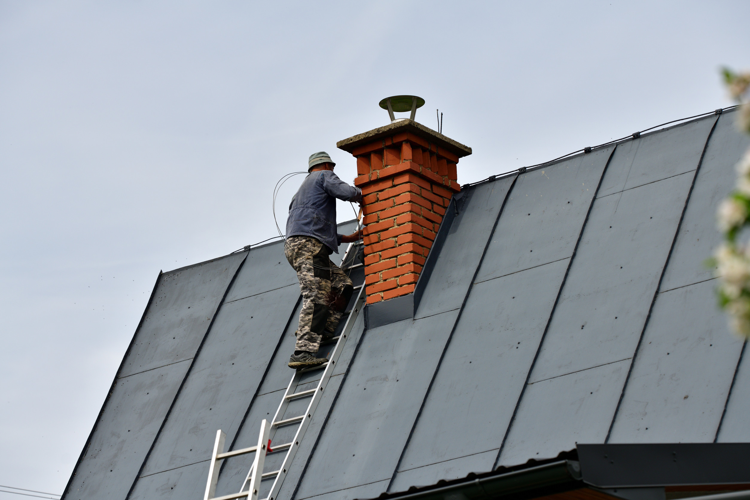 Traditional manual method of cleaning the chimney on the roof
