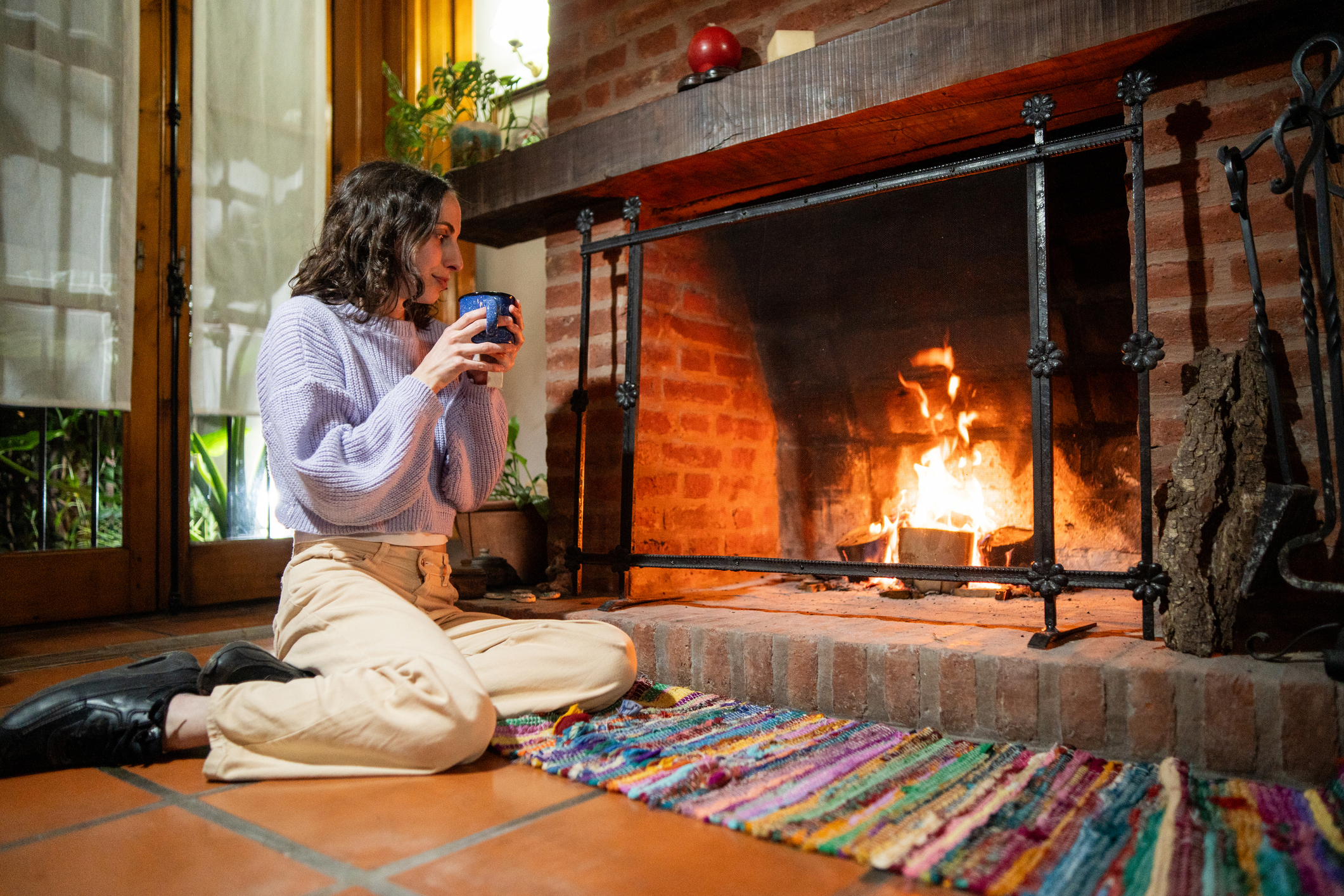 Young woman drinking tea in front of fireplace at home Smoke Back Into Home